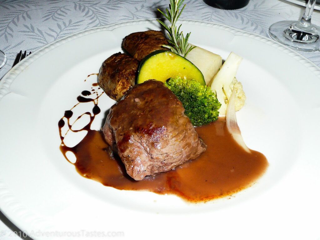 Meat and vegetables on a plate at Playa Mujeres resort in Mexico