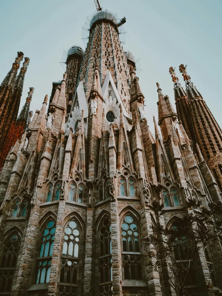 View through the trees of Barcelona's famous unfinished masterpiece, Gaudi's La Sagrada Familia church. It's a must-see when spending 3 days in Barcelona Photo by Mehmet Turgut Kirkgoz : https://www.pexels.com/photo/sagrada-familia-in-barcelona-spain-14364597/