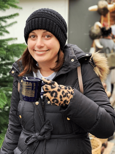 Lindsey from Adventurous Tastes enjoying one of her favorite Christmas cocktails - gluhwein from a mug at a European Christmas Market