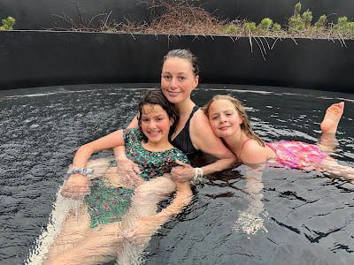 Mother and daughters enjoying a hot spring while traveling in Iceland