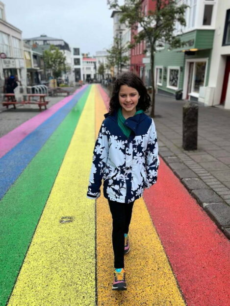 Girl from Adventurous Tastes walking on rainbow road in Reykjavik, Iceland