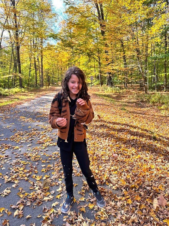 Little girl laughs on a hike in the Catskills in the fall