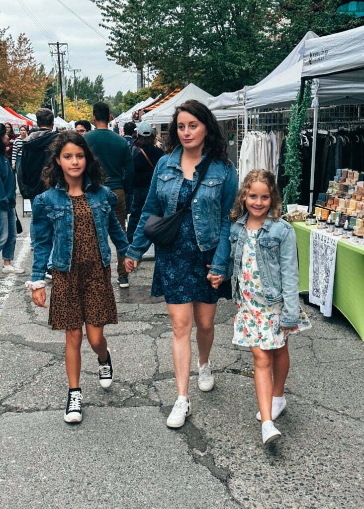 Woman and two daughters walking through Fremont Market in Seattle