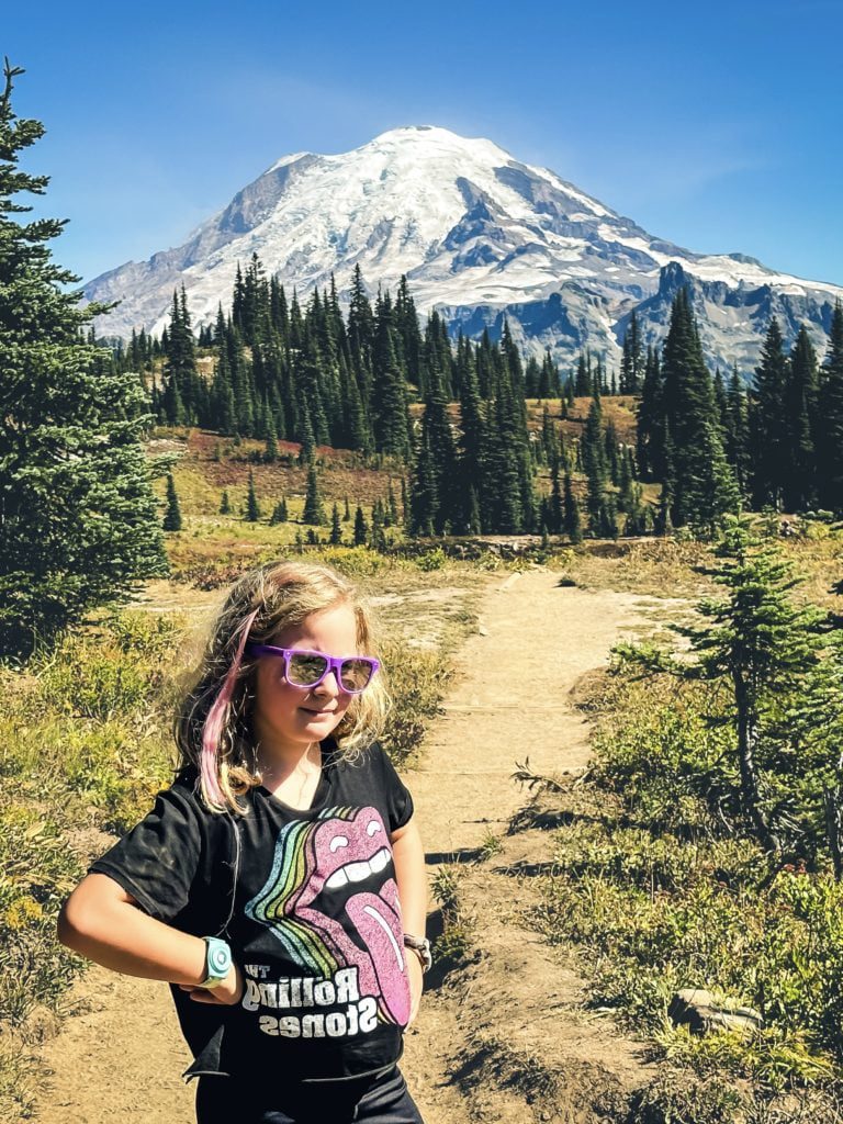 Young girl from Adventurous Tastes on Naches Peak Loop Trail with Mt. Rainier in the background