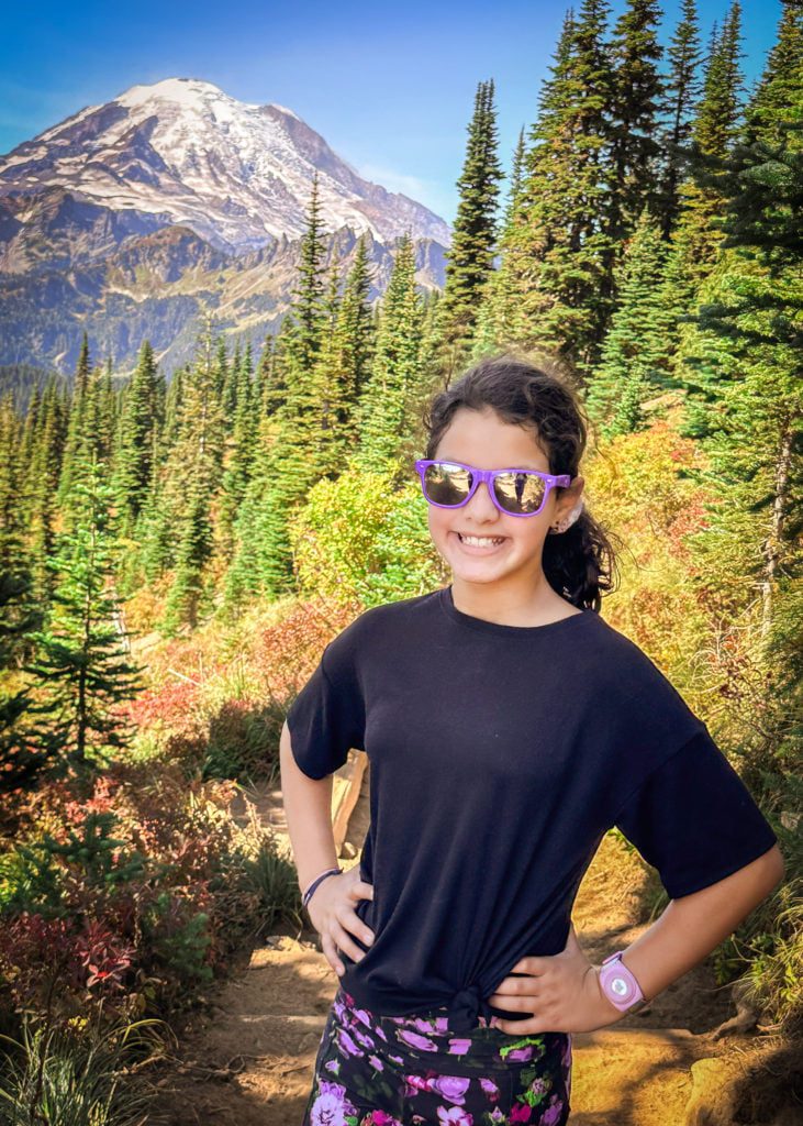 Young girl from Adventurous Tastes on Naches Peak Loop Trail with Mt. Rainier in the background