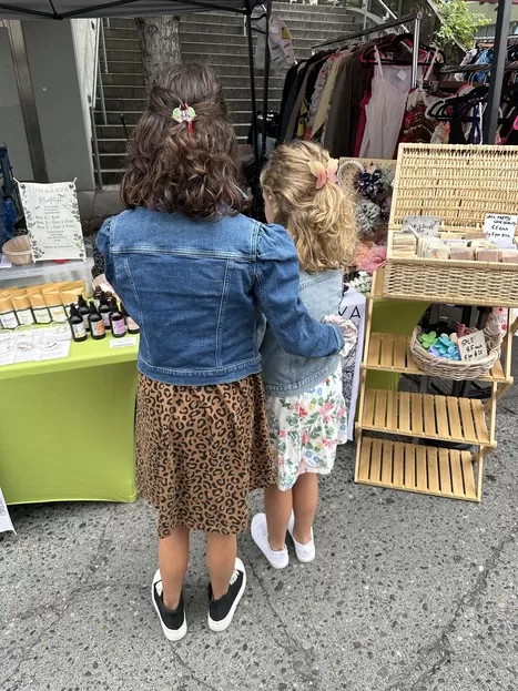 View from behind two girls shopping at Fremont Market in Seattle