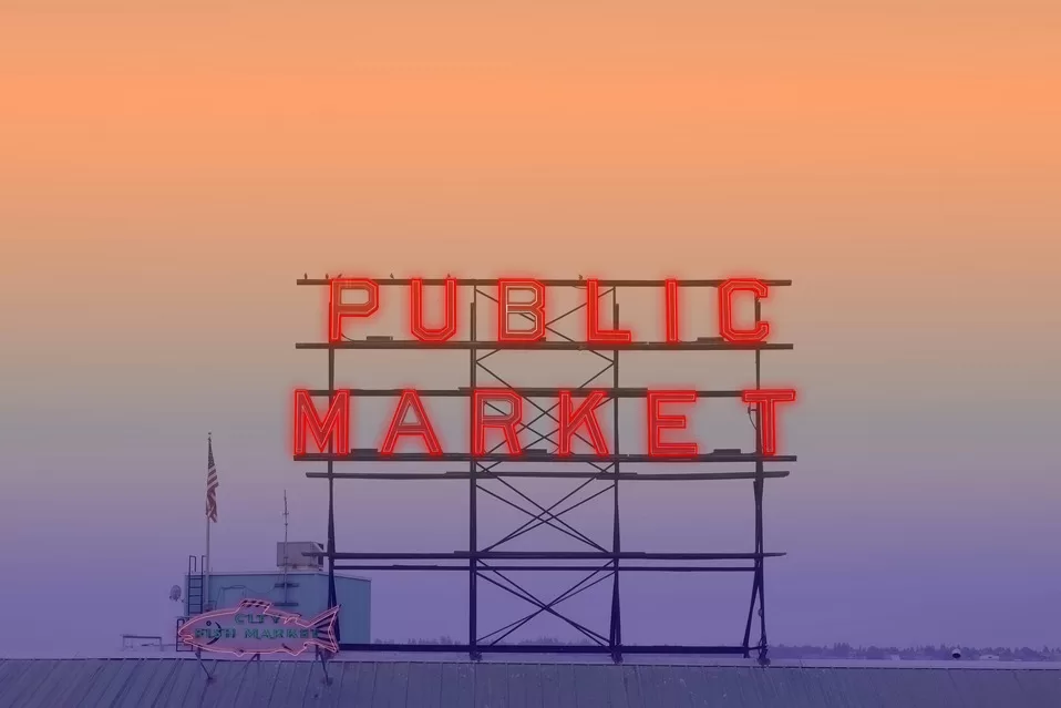 The famous Public Market sign at Seattle's Public Market with pink sunset sky behind it