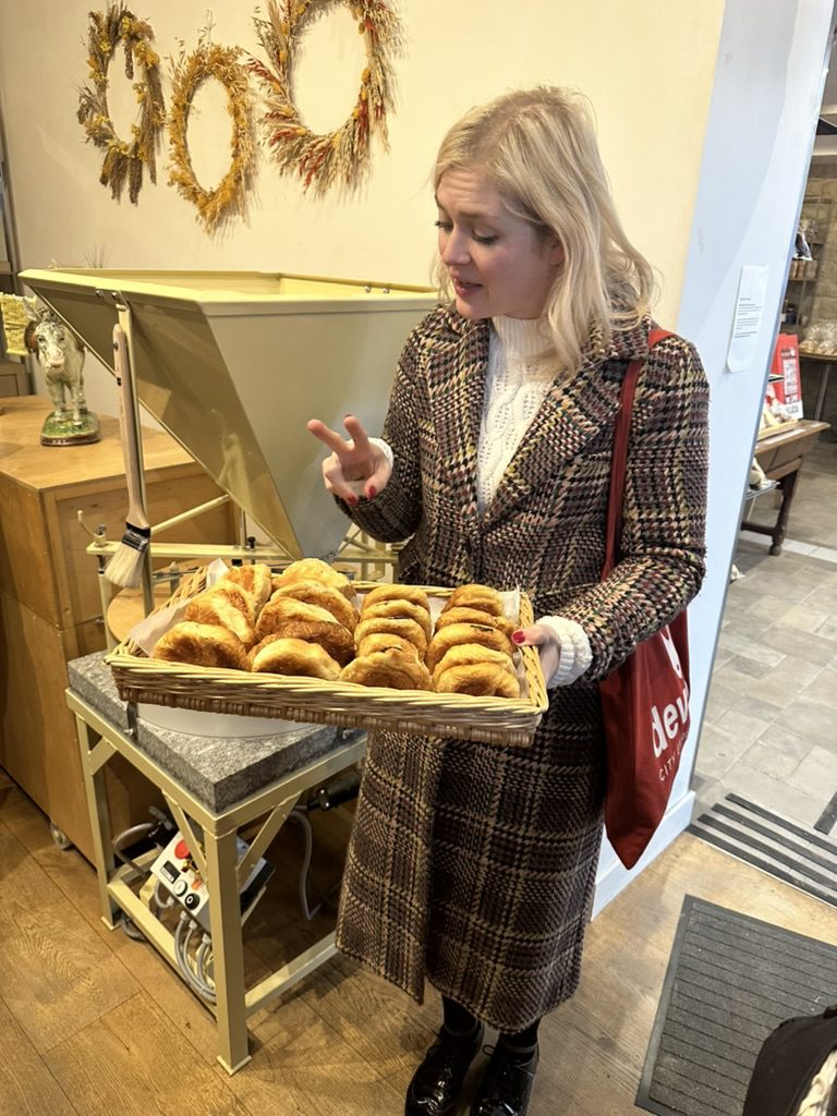 Women holding a tray of croissants in paris