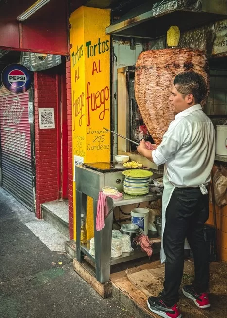 We went on a taco tour in Mexico City with kids and saw this man shaving el pastor tacos off a spit in Mexico City