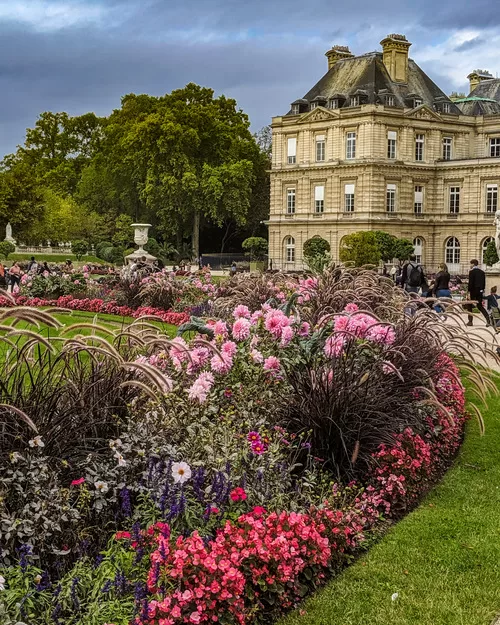 Flowers an an ornate castle in the Jardin du Luxembourg, one of the best places family activities in Paris
