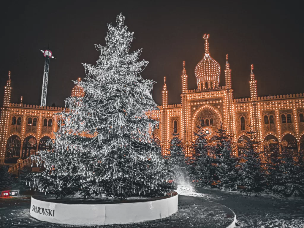 Glowing Christmas tree and ornate building at Tivol in Copenhagen