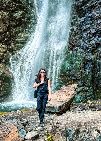 Woman walking in front of Geveleti Waterfall in Georgia