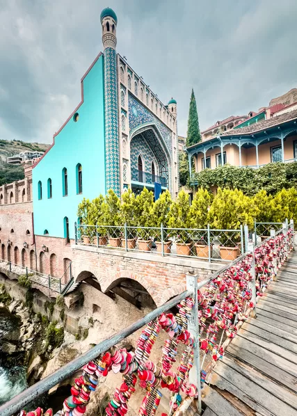Georgia travel often includes a stop at the sulpher baths - bridge in foreground with turqouise tiled sulpher bath building is in background