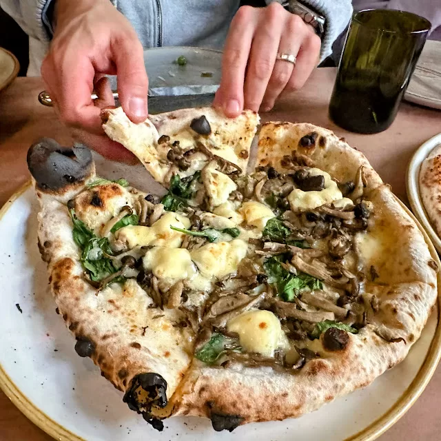 Adventurous Tastes | Pizza at San Francisco's A16 Close up of hands taking a slice of pizza a A16, a family-friendly restaurant in San Francisco, perfect when spending 4 days in Northern California with kids