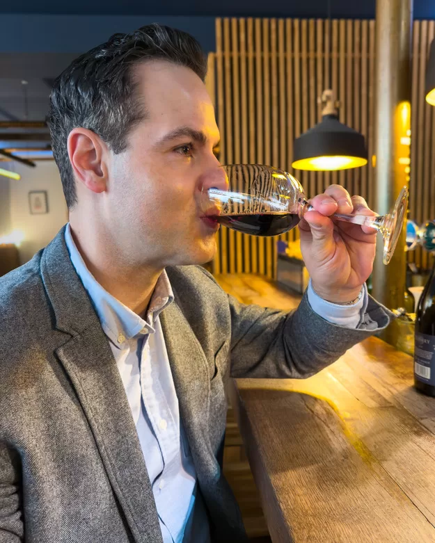 Jeff from Adventurous Tastes drinking red bordeaux wine at a bar in Bordeaux
