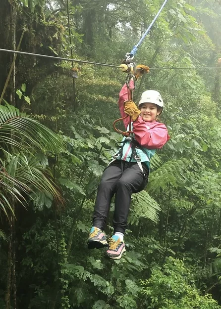 Ziplining is one of the top things to do in Costa Rica, one of the best family travel adventure destinations. A little girl ziplinines through the clouds in the cloud forests of Monteverde, Costa Rica