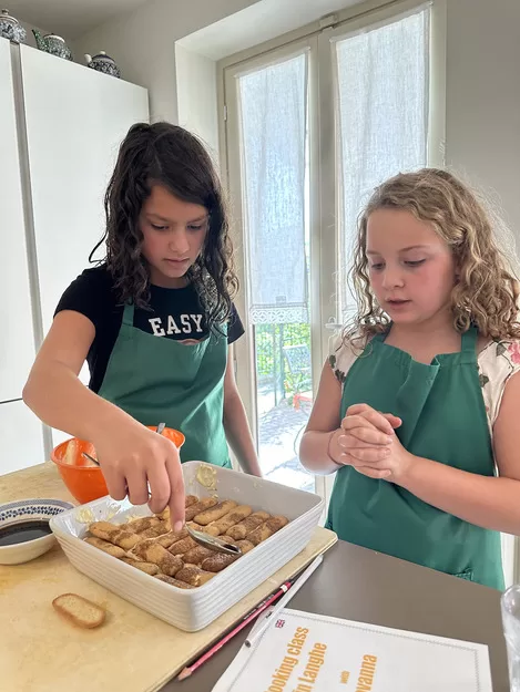 Two little girls making tiramisu when visiting Rome in two days, a perfect destination on a trip to Italy