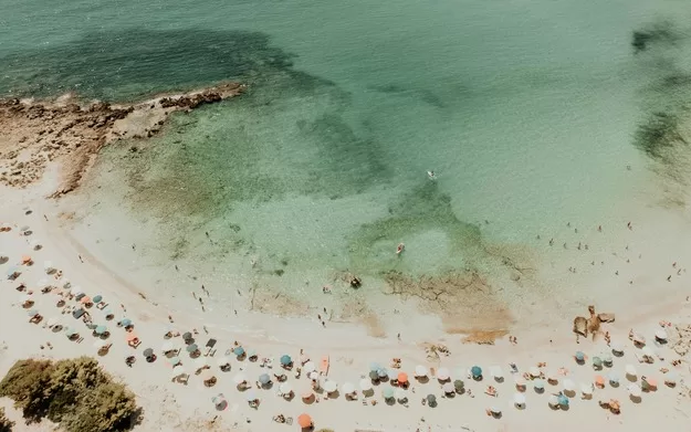 View of beach and turquoise water at a Puglia beach, a perfect destination for your trip to Italy