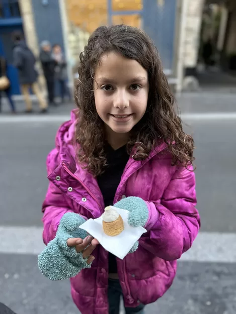 Little girl about to eat a sweet during her Paris food tour