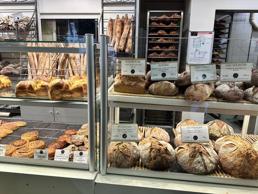 Breads in a glass case at a stop during a Paris food tour in Saint Germain