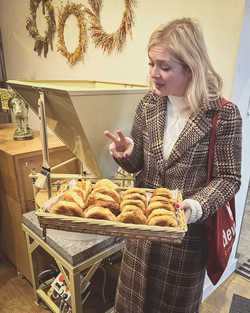 Paris food tour guide from Devour serving a tray of croissants