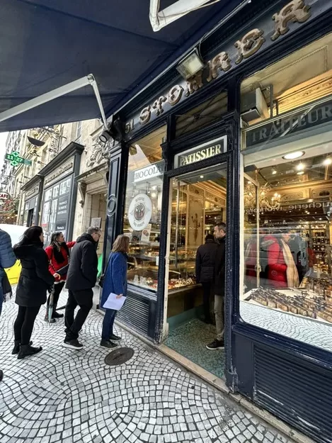 People standing in line at Stohrer patisserie in Paris
