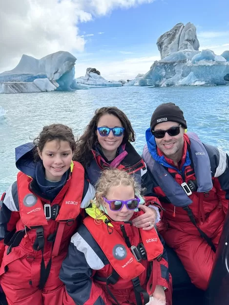 family in front of glaciers in Iceland - zodiac tour in Jokulsarlon is one of the best things to do in Iceland with kids