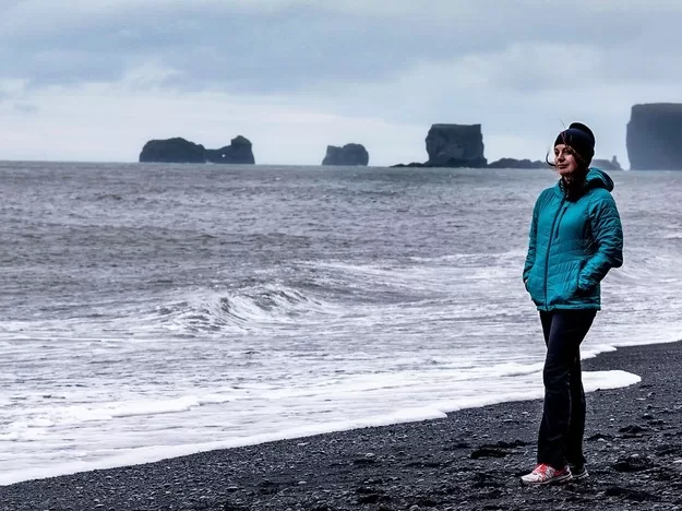 Woman walking on black Reynisfjara Beach